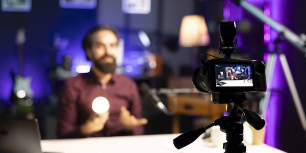 smiling tech guru reviewing smart light bulb in studio