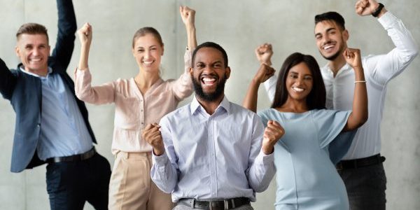 successful team. group of multiracial colleagues celebrating business achievement with raised fists